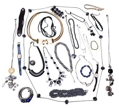 de nombreux colliers et bracelets de toutes sortes disposés sur une surface blanche