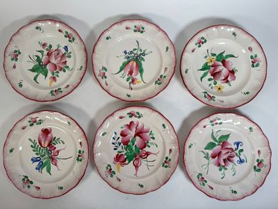 six plates with flowers painted on them sitting on a white surface