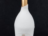 le flacon est blanc et doré, avec un bouchon doré