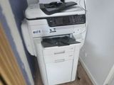a white printer sitting on top of a white cabinet