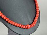 a close up of a mannequin with a red bead necklace on it