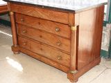 a wooden dresser with marble top in a room