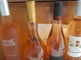 several bottles of rose wine are sitting on a wooden table