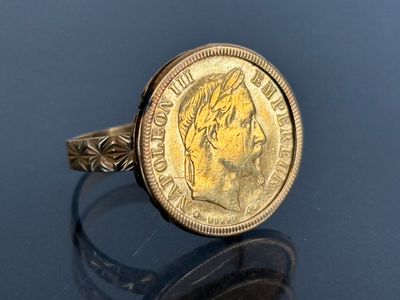 an image of a gold ring with a coin on it