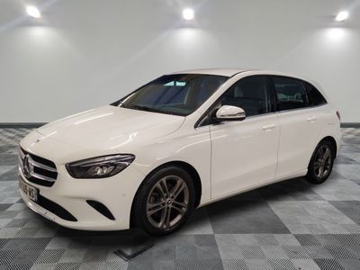 une Mercedes Classe B blanche garée sur un sol à damier