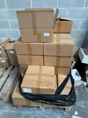 une pile de cartons posée sur une palette près d'un mur