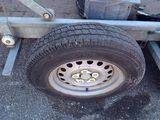 a flat tire on a trailer that is parked on the street