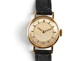 an image of a gold wrist watch with a black strap
