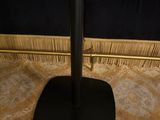 a black speaker on a black stand in a room