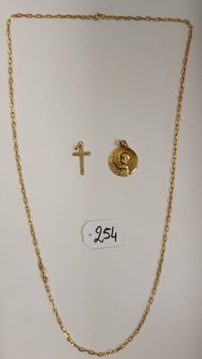 un gros plan d'un collier et d'une croix sur un fond blanc