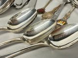 several silver spoons are lined up on a counter top