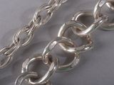 silver plated chain with a thick link on a white surface