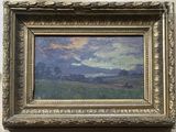 painting of a landscape in a gold frame on a white wall