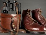 pair of brown boots and a bag with a pair of binoculars in it