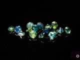 a close up of a bunch of blue and green gems on a black surface