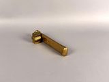 a small brass object on a white surface