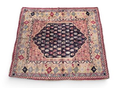 un ancien tapis persan à motifs géométriques sur fond blanc