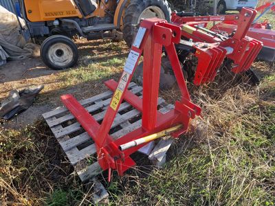 un tracteur immobilisé dans l'herbe, avec une charrue attelée derrière lui