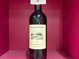 une bouteille de vin posée sur une étagère, dans une boîte rose