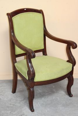 a green chair with a wooden frame and green upholstered seat