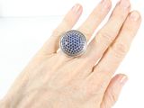 a woman ' s hand holding a ring with a blue and white design