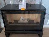 un petit poêle noir surmonté d'une porte vitrée