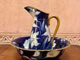 a blue and white pitcher sitting on a wooden table
