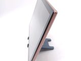 a tablet computer sitting on a stand on a white surface