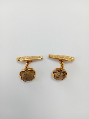 a pair of gold plated cufflinks with a picture of a man and a woman