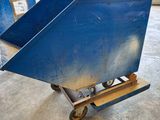 two blue bins sitting on a dolly in a warehouse