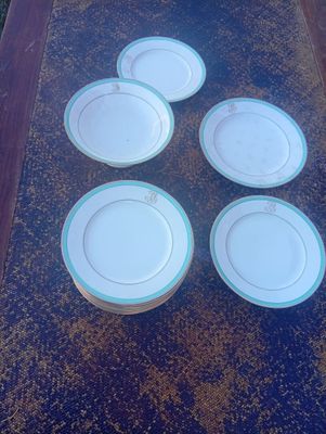 six assiettes blanches à bord bleu sont posées sur une table