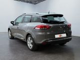 the rear of a grey car parked in a large room