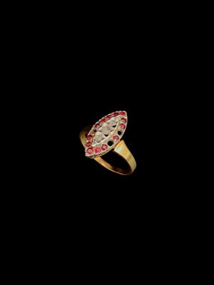gros plan d'une bague en or avec des pierres rouges et blanches