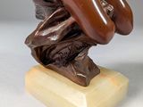 statue of a man holding a baseball bat on top of a wooden base