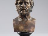 a bronze bust of a man with a beard on a pedestal