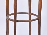 une image représentant un tabouret en bois avec une assise ronde sur fond blanc