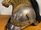 a silver helmet with black hair on a wooden table