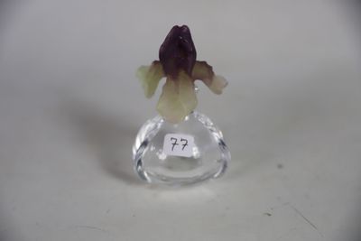 une petite figurine en verre contenant une fleur violette