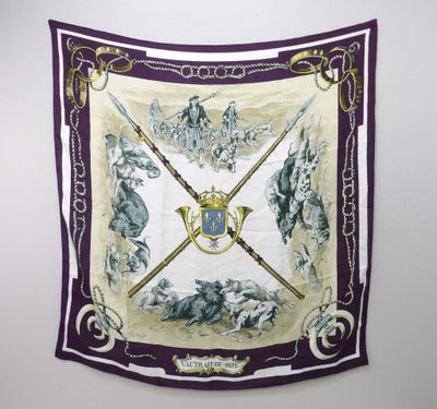 a purple and white scarf hanging on a wall next to a white wall