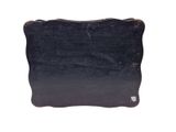 a black piece of wood that is on a white surface