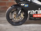 a black motorcycle parked in front of a brick wall