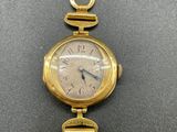 a close up of a wrist watch with a chain around it