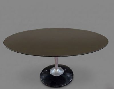 a round glass table with a black base and a metal base
