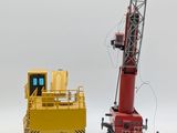 a toy crane that is sitting next to a toy truck