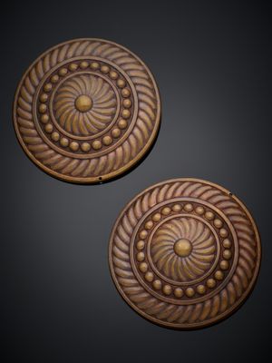 une paire de boutons en bois sculpté sur fond noir