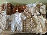 a lot of baby clothes on a bed in a room