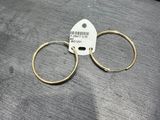 a close up of a pair of gold hoop earrings on a table