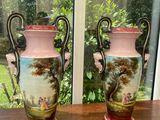 two vases sitting on a table in front of a window
