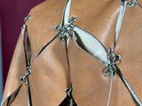 a close up of a woman ' s back wearing a leather dress