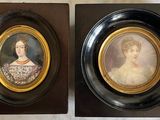two framed portraits of a woman and a man in formal dress